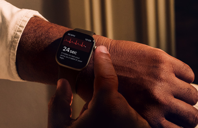 En person håller ner Digital Crown på Apple Watch Series 11 för att mäta hjärthälsan i EKG-appen